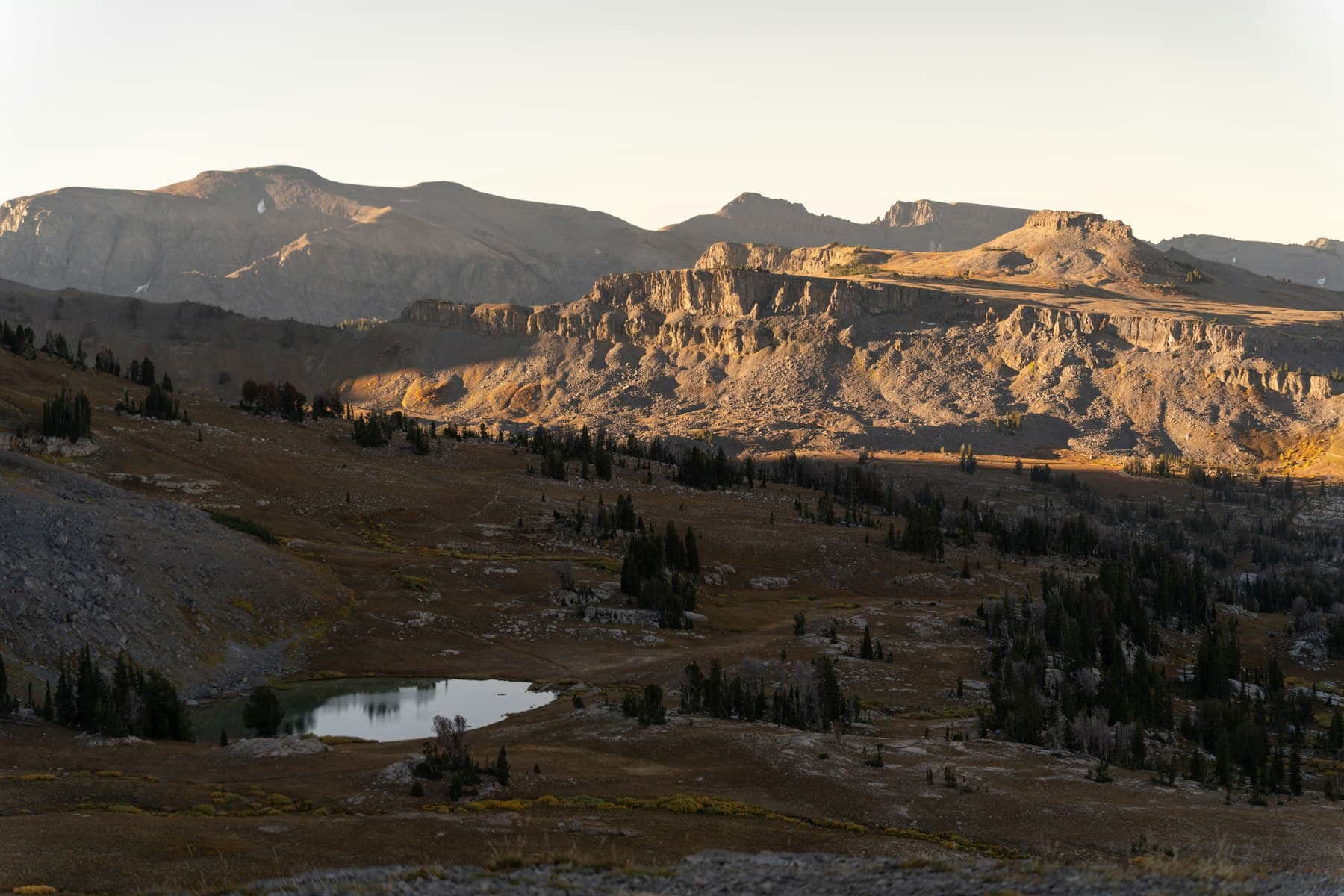 Sunlit mountain landscape with a small lake